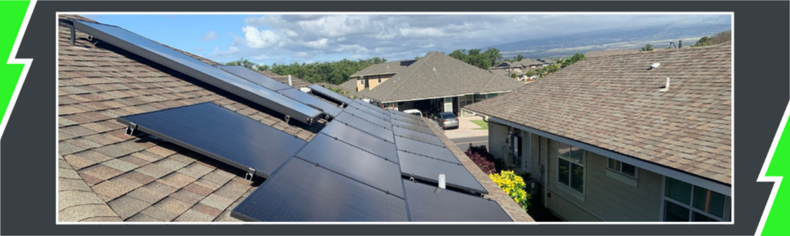 Solar panels and a solar water heater on a Hawaii home's roof with neighboring homes and the coastline beyond